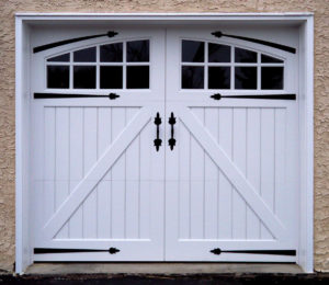 white vinyl garage door with decorative hardware handles and straps and two arched window panels 