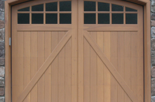 Arched garage door windows on a wooden garage door