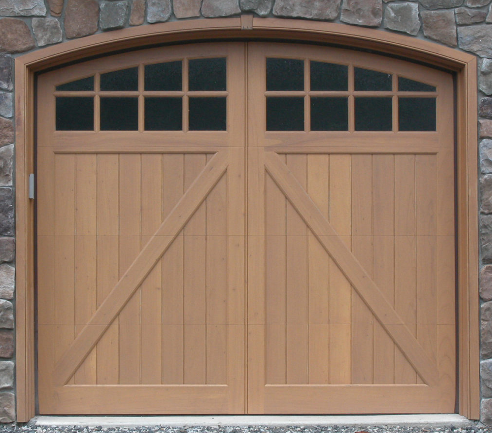 Arched garage door windows on a wooden garage door