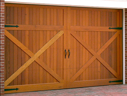 Wooden barn style garage door on a brick garage.