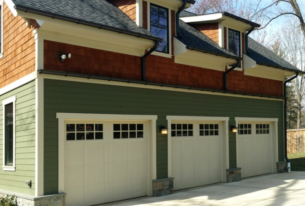 White Wood Garage Doors In A Three Car Green and Natural Wood Detached Garage