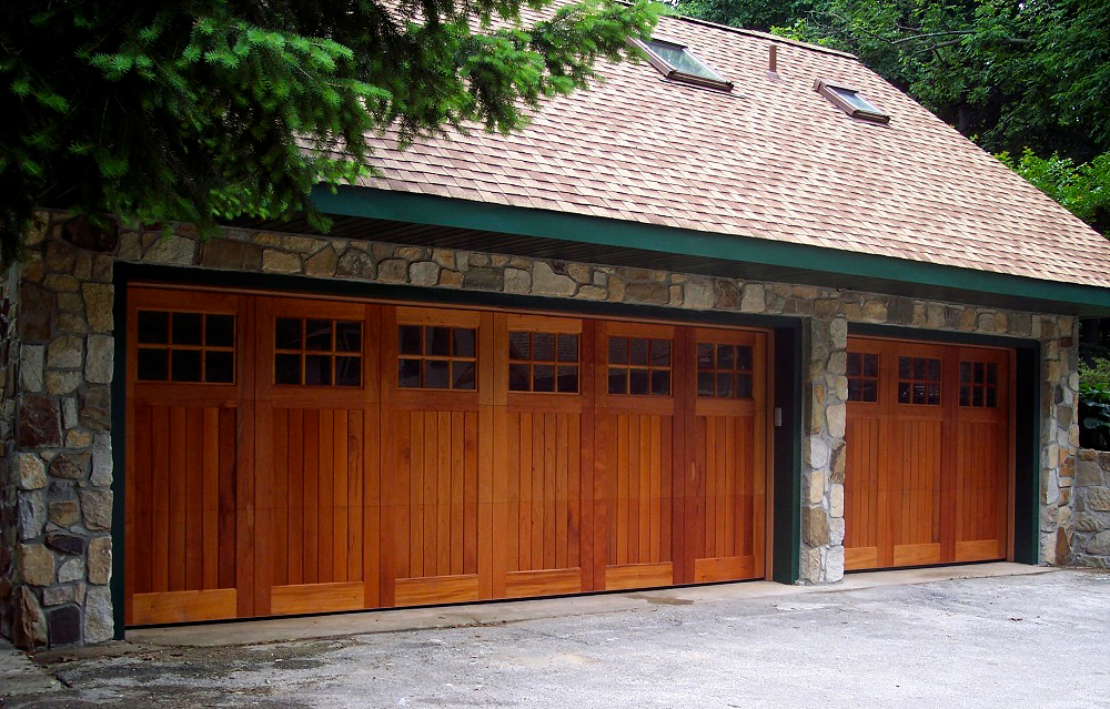 Two car stone garage with brown real wood garage doors