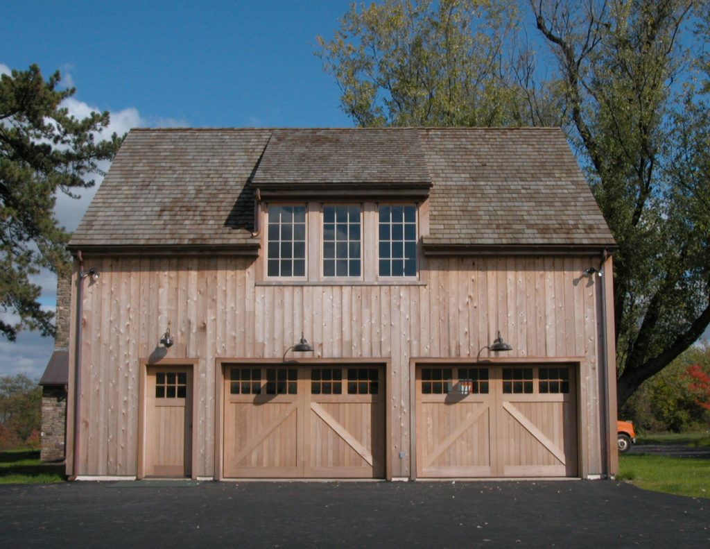 Custom stained slide out carriage style garage door on a natural wood detached garage