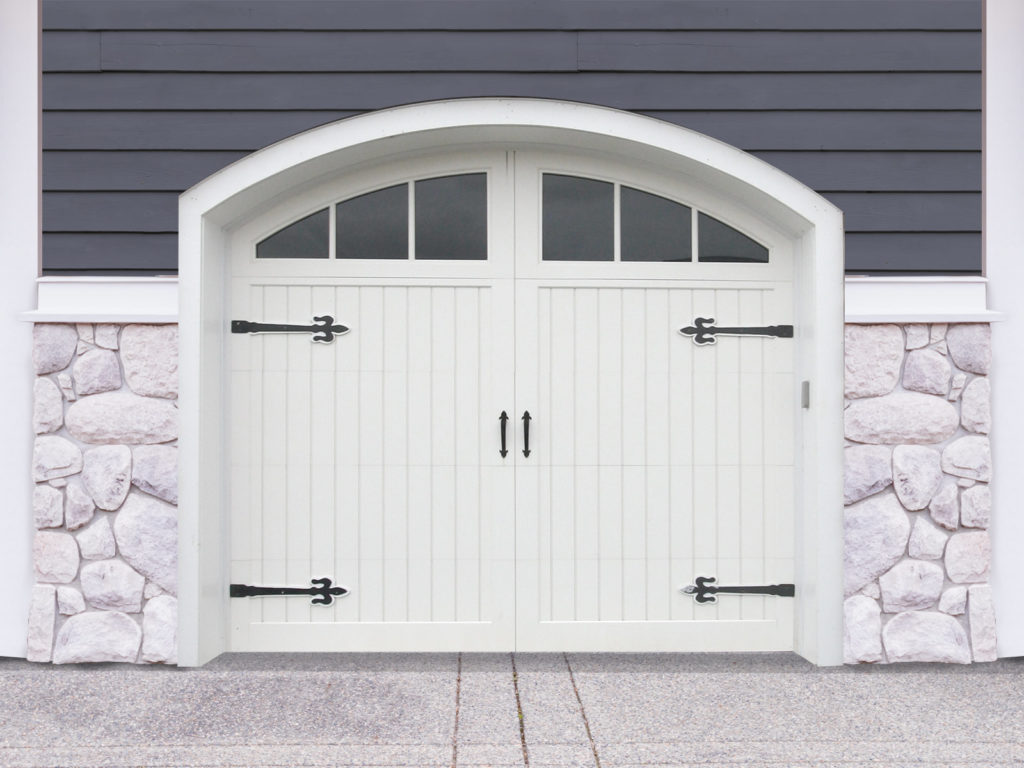 Arched white vinyl carriage garage door with two windows, door straps, and handles