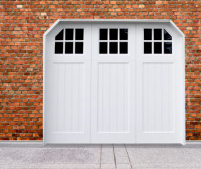 White vinyl carriage house garage door with three windows and panels