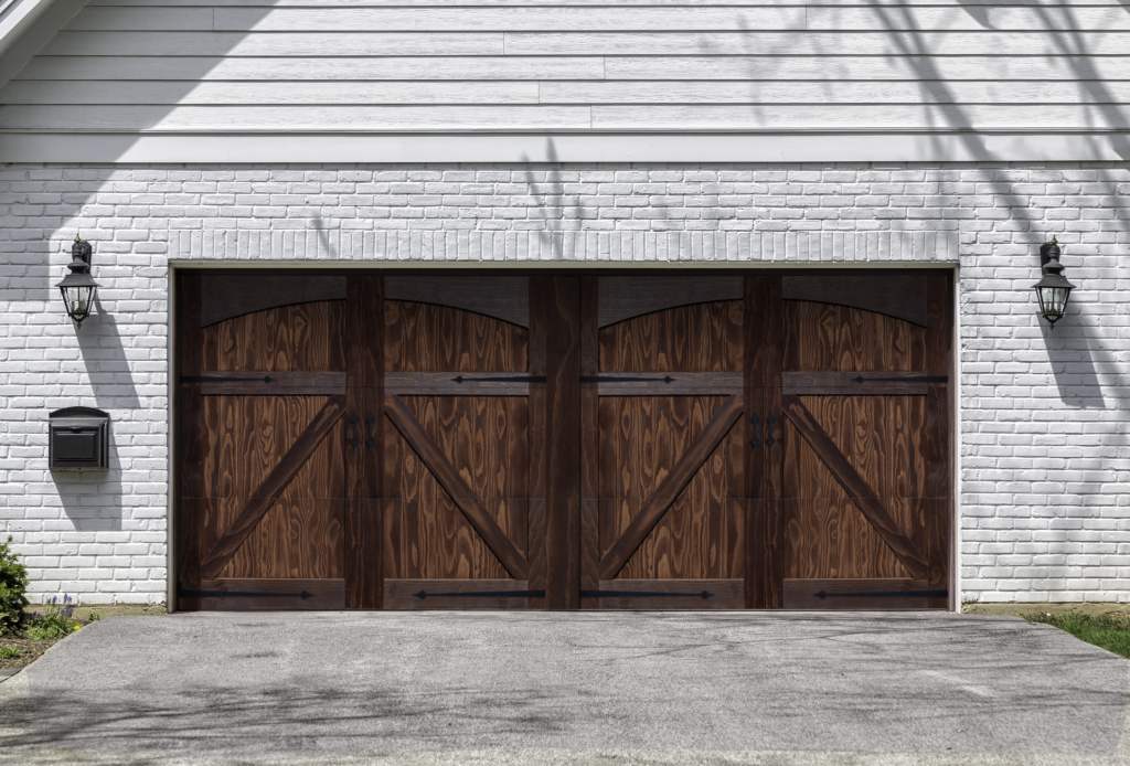 Double swing style mahogany stained accoya wood garage door on a white stone garage