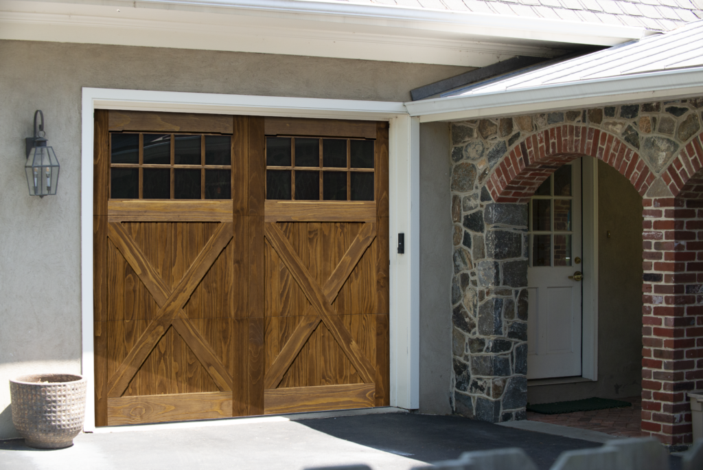 Swing style accoya wood garage door with x bucks and rosewood stain on garage