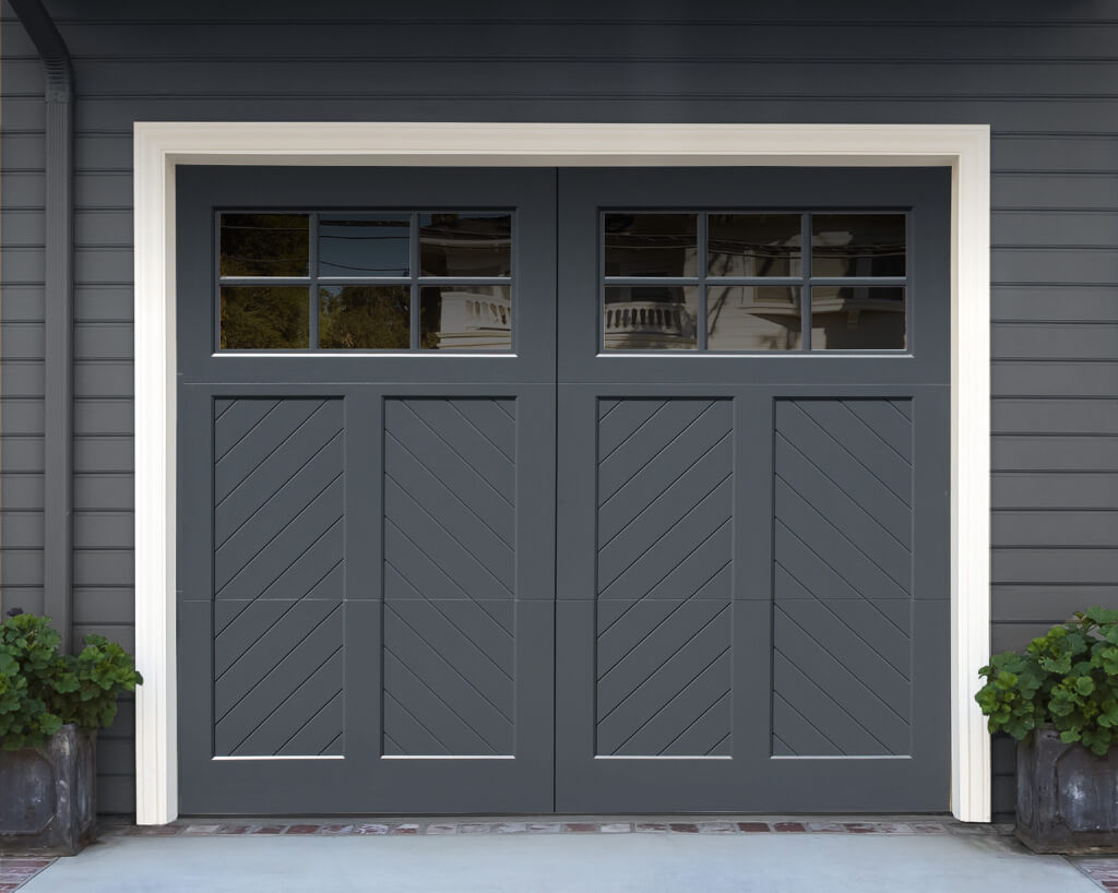 Grey wooden bifold garage door with herribone trim