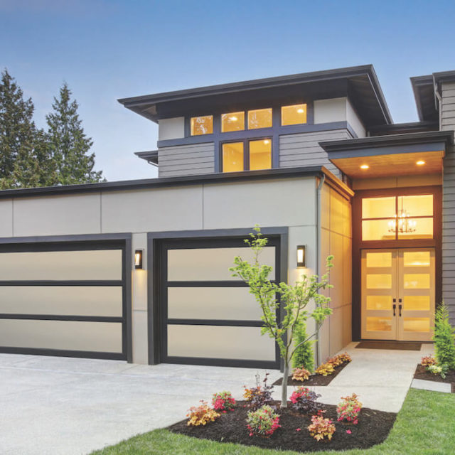 Modern glass garage doors installed on a white, modern house