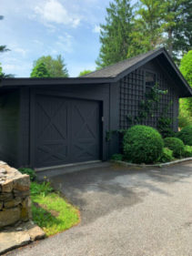 Black stained accyoa wood garage door on a detached black garage