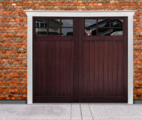 Dark brown stained wooden garage door with rectangular windows on brick garage