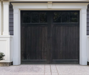 Black stained wooden carriage garage door with two windows