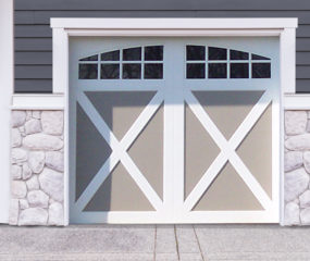 White and gray faux wood garage door with x crossbuck panels and two windows