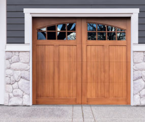 Golden oak stained faux wood carriage garage door with two windows