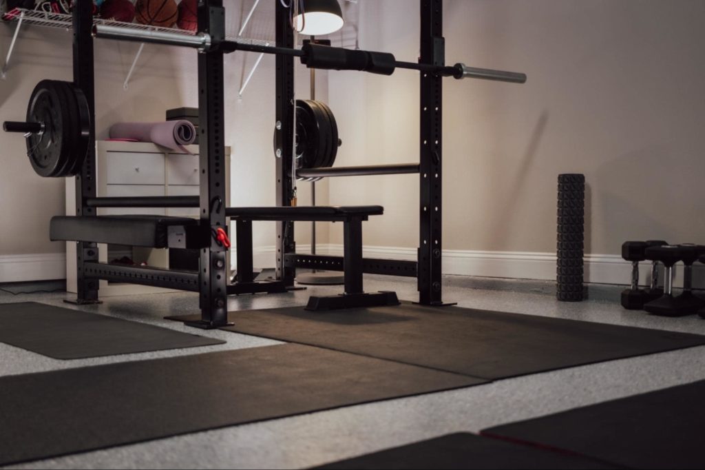 A garage gym with weights and a squat rack. 