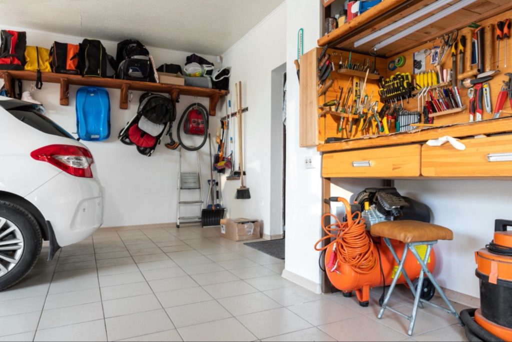 A garage space that is well organized with shelves and hooks. 