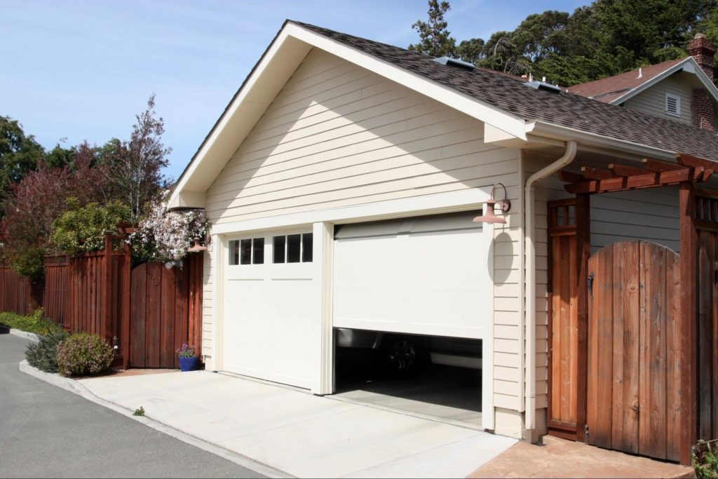 A garage door that's half open and exposing what's inside. 