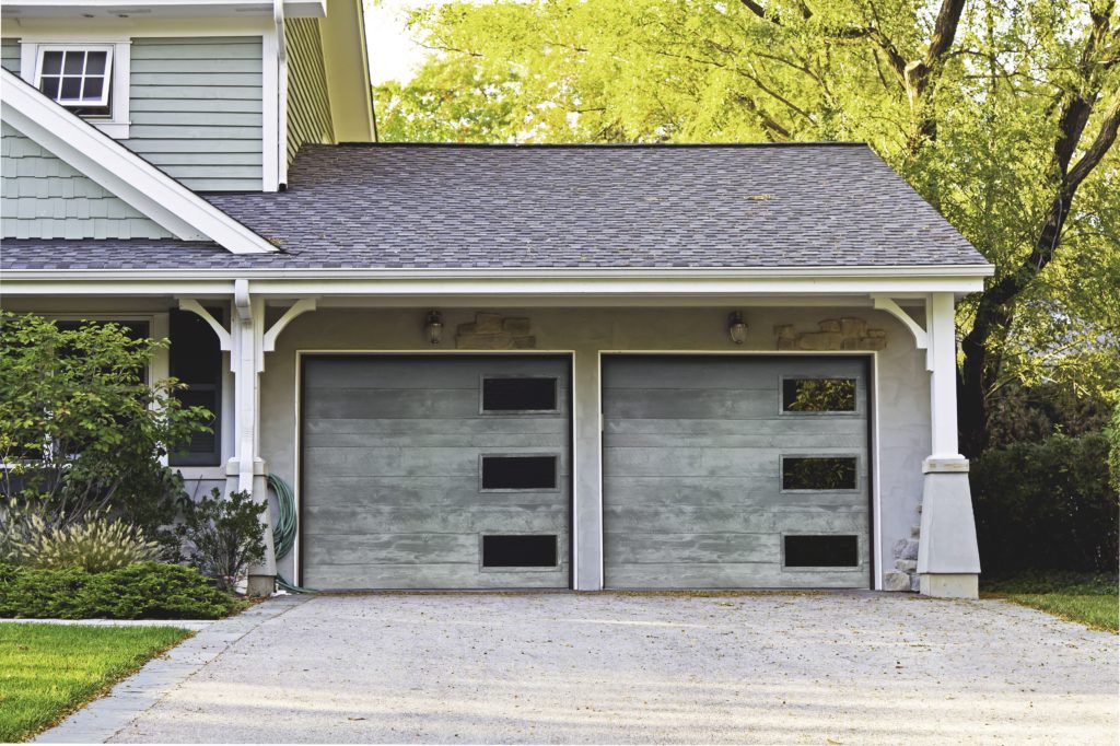 a full view of a double garage door with windows on the right side of each garage door. 