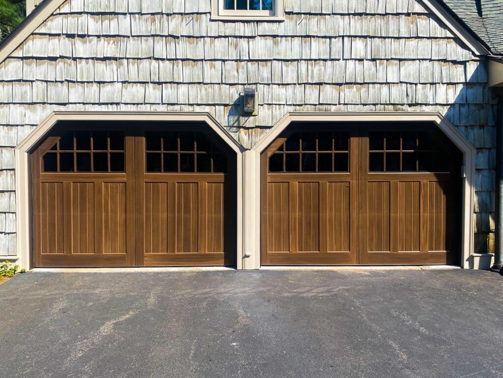 a double garage door with an exterior light in the middle of the two doors.