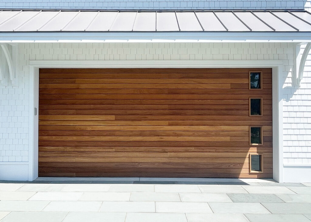 a wooden garage door with four small windows down the right side.