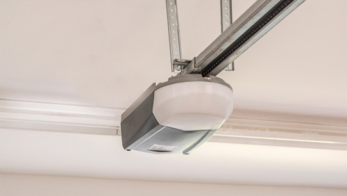 Garage door opener on a track in a white garage