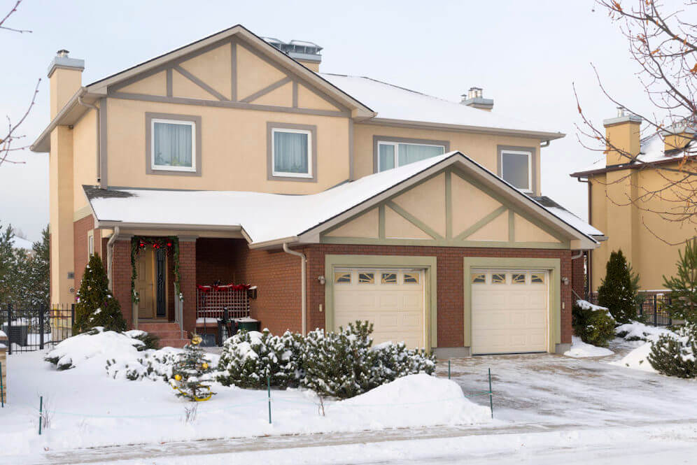 View of two door garage home in the snow