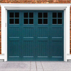 Teal wooden garage door with four windows, cross rails on brick garage