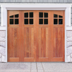 Natural brown wooden garage door with four windows on gray wood and stone garage