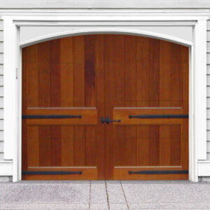 Brown arched swing out wooden garage door with no windows, door straps on white vinyl garage
