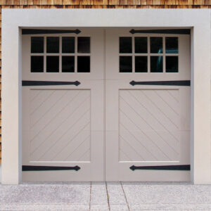 Light gray swing out garage door with two windows, and door straps on brown wood garage