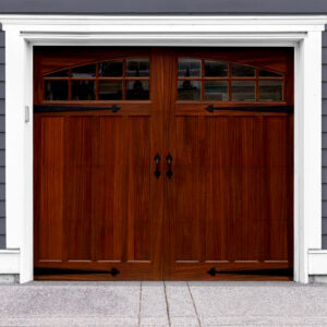 Dark brown wooden swing out carriage garage door with two arched windows and door straps