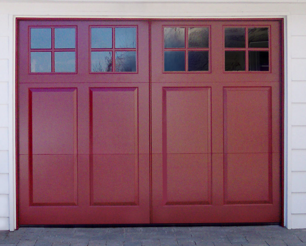Mullioned garage door windows on a red-stained wooden garage door on a white vinyl garage