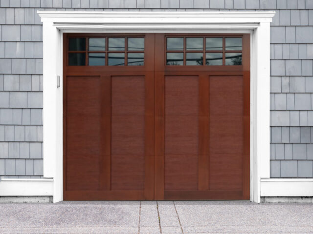 Mahogany stained faux wood swing out garage door with two windows