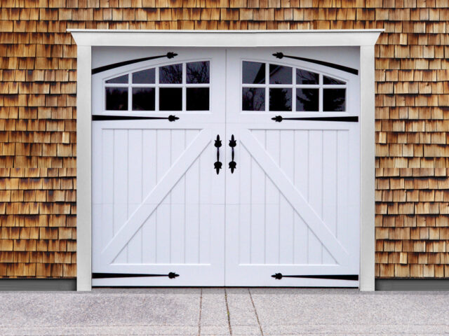 White vinyl carriage garage door with z buck panels, two windows, door straps, and door handles