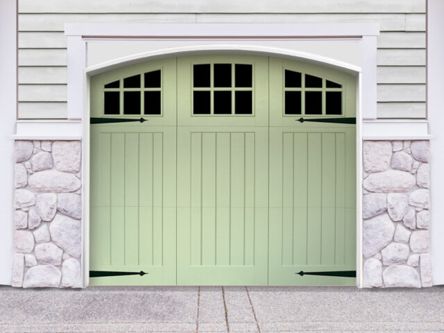 Green vinyl carriage house garage door with three panels and windows with door straps