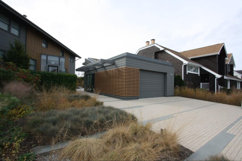 A grey paneled modern wood garage door with cladding