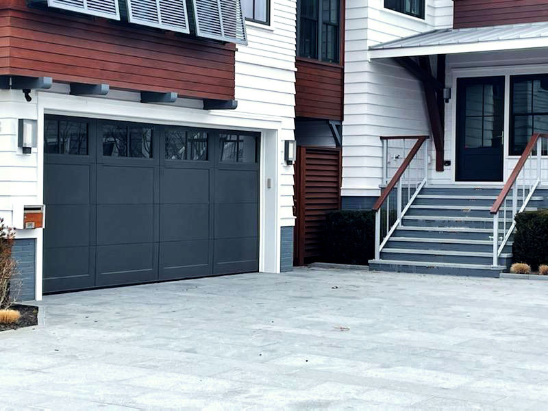 a navy blue garage door with four windows and four panels.